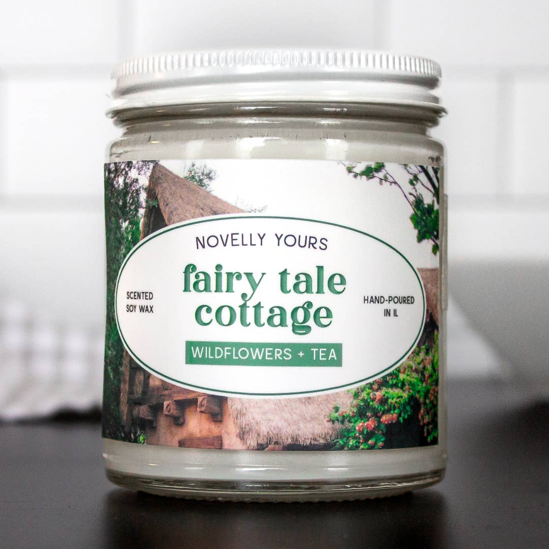 Candle jar labeled 'fairy tale cottage' with a scenic design on the label.