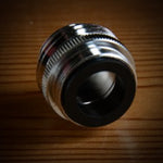 Metallic cylindrical object on a wooden surface