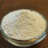 Glass container filled with a powdery substance on a wooden surface