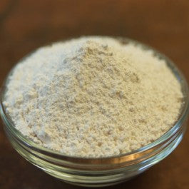 Glass container filled with a powdery substance on a wooden surface