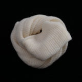 White knitted Muslin bag coiled on a black background