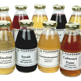 A group of Fulkerson Pasteurized Juice bottles. Clear bottles with Gold Caps on a clear background. 