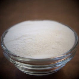 Glass bowl filled with white powder on a dark background
