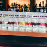Row of Winosaur wine packages on a bar counter with a blurred bar background