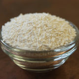 Glass jar filled with small white pellets on a wooden surface