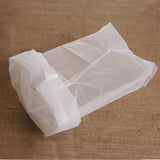 White mesh straining bag on a wooden surface