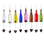 Colorful glass bottle wind chimes with cork stoppers and heart-shaped weights on a white background
