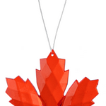Red paper maple leaf ornament on a white background
