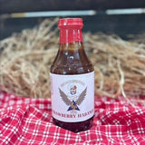 barbecue sauce bottle on red table cloth with a straw hay background