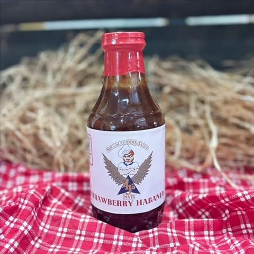 barbecue sauce bottle on red table cloth with a straw hay background