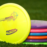 Stack of colorful disc golf discs on grass