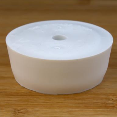 White rubber bottle stopper with hole on a wooden background