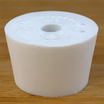 White rubber bottle stopper with hole on a wooden background