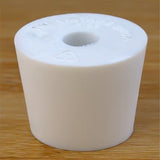 White rubber bottle stopper with hole on a wooden background