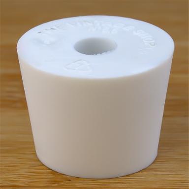 White rubber bottle stopper with hole on a wooden background