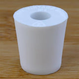 White rubber bottle stopper with hole on a wooden background