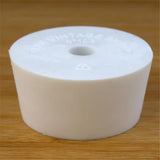 White rubber bottle stopper with hole on a wooden background