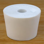 White rubber bottle stopper with hole on a wooden background