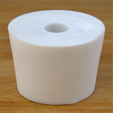 White rubber bottle stopper with hole on a wooden background
