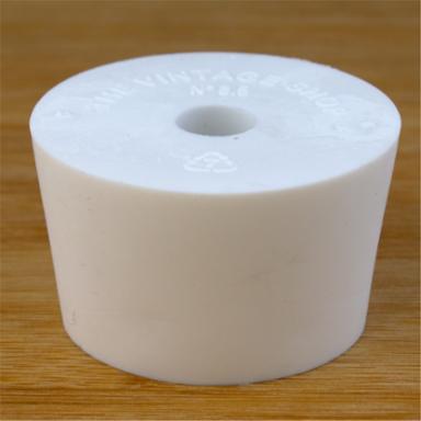 White rubber bottle stopper with hole on a wooden background