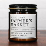 Candle jar labeled 'Farmer's Market' on a wooden surface with a white background