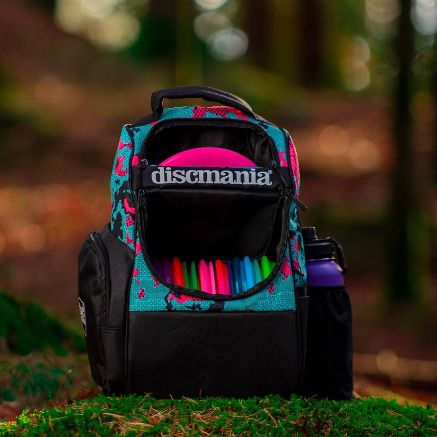 Backpack with colorful discs and Discmania branding on a blurred natural background