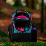 Backpack with colorful discs and Discmania branding on a blurred natural background