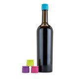 Dark glass bottle with a blue cap and three colorful silicone bottle caps on a white background
