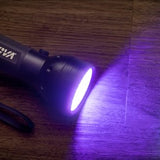 UV flashlight emitting purple light on a wooden surface