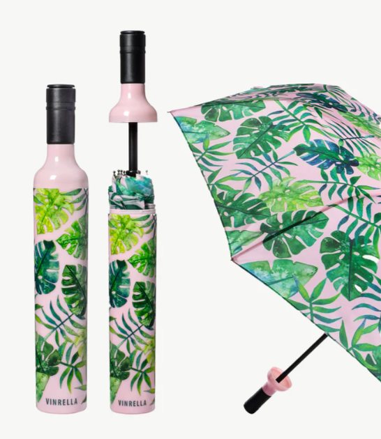 Tropical leaf patterned umbrella with pink handle and frame on a white background