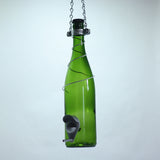 Green glass wine bottle with a metal bird feeder attached on a white background
